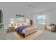 Bright bedroom with beach-themed decor, a ceiling fan, and a cozy seating area near the window at 3283 Dawn Pl, The Villages, FL 32163