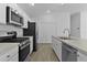 Contemporary kitchen with stainless steel appliances, ample counter space, and bright white cabinets at 3283 Dawn Pl, The Villages, FL 32163
