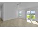 Bright main bedroom with large windows, wood floors, ceiling fan, and sliding glass door access to the outside at 3283 Dawn Pl, The Villages, FL 32163