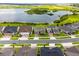 Aerial view of homes in a community with a scenic lake and lush green surroundings at 3304 Canna Lily Pl, Clermont, FL 34711