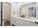 Bright bathroom featuring double sinks, white cabinets, and a shower with white tiling and a curtain at 3304 Canna Lily Pl, Clermont, FL 34711