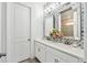 Modern bathroom featuring double sinks, stylish mirrors, and marble tiling at 3304 Canna Lily Pl, Clermont, FL 34711