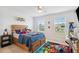 A bright, cozy bedroom with a wooden bed frame, colorful accents, and natural light streaming through the windows at 3304 Canna Lily Pl, Clermont, FL 34711