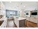 Modern kitchen open to the living room with island seating, stainless appliances, and hardwood floors at 3304 Canna Lily Pl, Clermont, FL 34711