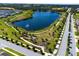 Scenic view of the community lake, walking path, and lush landscaping in a beautiful setting at 3304 Canna Lily Pl, Clermont, FL 34711