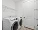 Functional laundry room with modern appliances, stylish tiled floor, and storage shelf at 3304 Canna Lily Pl, Clermont, FL 34711