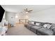 A spacious living room with a large sectional sofa, staircase view and neutral tones create a relaxing atmosphere at 3304 Canna Lily Pl, Clermont, FL 34711