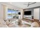 Bright living room featuring an outdoor view, comfortable seating, and contemporary entertainment center at 3304 Canna Lily Pl, Clermont, FL 34711