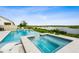 Inviting pool and spa combo overlooking a serene lake, with lush greenery completing the idyllic backyard setting at 3304 Canna Lily Pl, Clermont, FL 34711