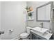 Bright powder room featuring a vessel sink, modern fixtures, a decorative mirror, and floating shelves with plant decor at 3304 Canna Lily Pl, Clermont, FL 34711