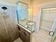 Bathroom featuring a tiled shower and a granite vanity with a built-in cabinet above the toilet at 3607 Umbrella Tree Ln, Oxford, FL 34484
