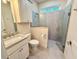 Bathroom featuring a shower stall with a glass enclosure and a granite vanity with a built-in cabinet at 3607 Umbrella Tree Ln, Oxford, FL 34484