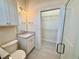 Bright bathroom with a granite vanity, tiled floors, a mirrored wall and shower with glass doors at 3607 Umbrella Tree Ln, Oxford, FL 34484
