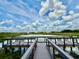 Scenic lake view from the community dock, featuring comfortable seating areas for residents to relax and enjoy nature at 3607 Umbrella Tree Ln, Oxford, FL 34484