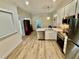 Open-concept kitchen showcasing stainless steel appliances, quartz countertops, and modern lighting at 3607 Umbrella Tree Ln, Oxford, FL 34484