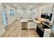 Bright kitchen with white cabinetry, stainless steel appliances, and a center island with seating at 3607 Umbrella Tree Ln, Oxford, FL 34484