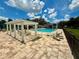 Inviting community pool with lounge chairs, sun umbrellas, and shade pergola at 3607 Umbrella Tree Ln, Oxford, FL 34484