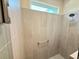 Tiled shower area with a rain shower head and a shower caddy mounted on the wall at 3607 Umbrella Tree Ln, Oxford, FL 34484