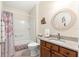 Bathroom with shower-tub combination, round mirror and wood vanity at 362 Arbella Loop, The Villages, FL 32162