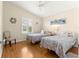 Bright bedroom featuring hardwood floors, twin beds, and a ceiling fan at 362 Arbella Loop, The Villages, FL 32162