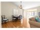 Bright dining room with wood floors, stylish lighting, and an open view to the living area at 362 Arbella Loop, The Villages, FL 32162
