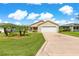 Inviting single-story home with a manicured lawn, palm trees, and a two-car garage at 362 Arbella Loop, The Villages, FL 32162