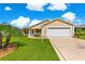 Charming single-story home with a well-manicured lawn, decorative driveway, and attached two-car garage at 362 Arbella Loop, The Villages, FL 32162
