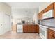 Open kitchen with wooden cabinets, tile floors, and modern appliances at 362 Arbella Loop, The Villages, FL 32162