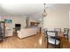 Bright living room with hardwood floors, comfortable seating, and an open layout to the dining area and kitchen at 362 Arbella Loop, The Villages, FL 32162