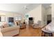 Cozy living room featuring hardwood floors, comfortable sofas, and an open layout to the kitchen at 362 Arbella Loop, The Villages, FL 32162