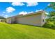 Large side yard with well maintained lawn, mature trees and the home's exterior at 362 Arbella Loop, The Villages, FL 32162