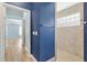 Bathroom with a shower stall, blue walls, and views into bedroom hallway at 3759 Orient Ave, The Villages, FL 32163