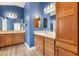 Bathroom with dual sinks, linen cabinet, and wood cabinetry at 3759 Orient Ave, The Villages, FL 32163