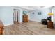 Large bedroom with a tray ceiling, a ceiling fan, wood floors, and view to en suite bathroom at 3759 Orient Ave, The Villages, FL 32163