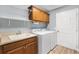 Well-equipped laundry room with wooden cabinets, a utility sink, and modern washer and dryer at 3759 Orient Ave, The Villages, FL 32163