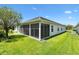 View of rear screened in porch of home with beautiful green lawn and landscaping at 3759 Orient Ave, The Villages, FL 32163