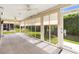 Bright sunroom featuring tile flooring, ceiling fans, and large windows overlooking the lush green backyard at 3759 Orient Ave, The Villages, FL 32163