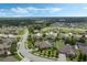 An aerial shows the home in its neighborhood, with greenery, a pool, nearby houses and a glimpse of a distant lake at 4018 Chandler Estates Dr, Apopka, FL 32712