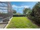 Well-maintained backyard with green lawn, mature trees, and screened-in pool view at 4018 Chandler Estates Dr, Apopka, FL 32712