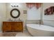 Bathroom with a soaking tub, granite countertop, dual sinks, elegant fixtures and decorative mirror at 4018 Chandler Estates Dr, Apopka, FL 32712