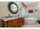 Bathroom with dual sinks, granite countertop, soaking tub and elegant fixtures and lighting at 4018 Chandler Estates Dr, Apopka, FL 32712