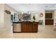 Modern kitchen island with built-in dishwasher, dark wood cabinets, and granite countertop, flowing into the living space at 4018 Chandler Estates Dr, Apopka, FL 32712