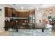 Close-up of kitchen island with granite countertop and stone accents, complemented by dark wood cabinetry and stainless appliances at 4018 Chandler Estates Dr, Apopka, FL 32712
