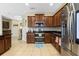 Well-appointed kitchen with dark wood cabinets, granite countertops, stainless steel appliances, and tiled backsplash at 4018 Chandler Estates Dr, Apopka, FL 32712