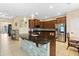 Open-concept kitchen with center island, stainless steel appliances, dark wood cabinets, and adjacent dining area at 4018 Chandler Estates Dr, Apopka, FL 32712