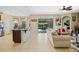 Open-concept living space with kitchen island, comfortable seating, and access to the screened patio and pool area at 4018 Chandler Estates Dr, Apopka, FL 32712