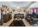 Spacious living room with a decorative tray ceiling, chandelier, and elegant brown leather furniture at 4018 Chandler Estates Dr, Apopka, FL 32712