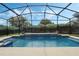 Screened-in pool with waterfall feature and lush landscaping offers a private oasis at 4018 Chandler Estates Dr, Apopka, FL 32712