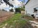 Wide-angle view of a spacious, partially overgrown backyard enclosed by a wooden fence at 402 E Maple St, Winter Garden, FL 34787