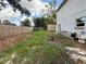 Wide-angle view of a spacious, partially overgrown backyard enclosed by a wooden fence at 402 E Maple St, Winter Garden, FL 34787